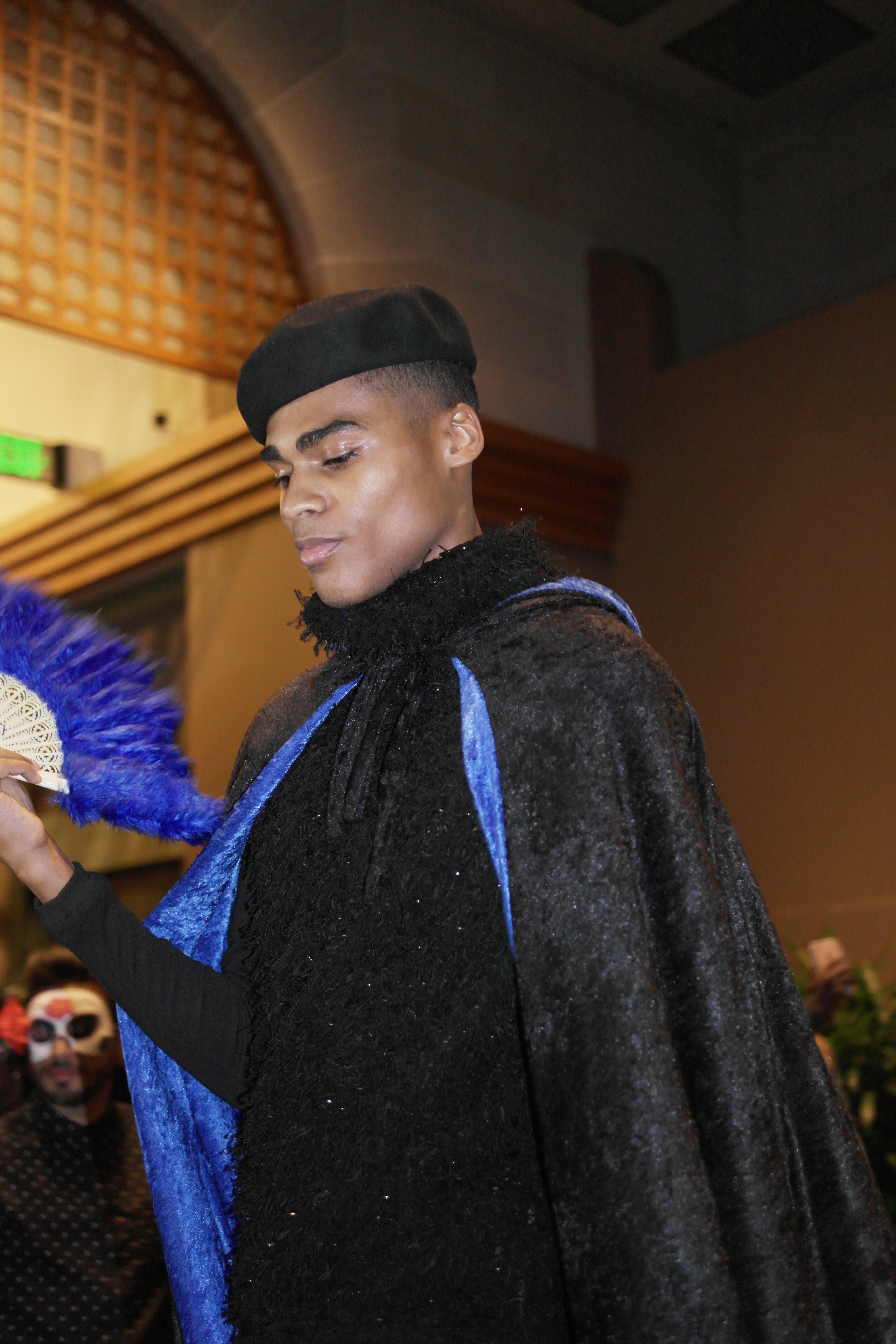 A voguing performer presenting at a masquerade ball.