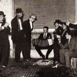 Historic Argentine tango dancers and musicians with a bandoneon player.