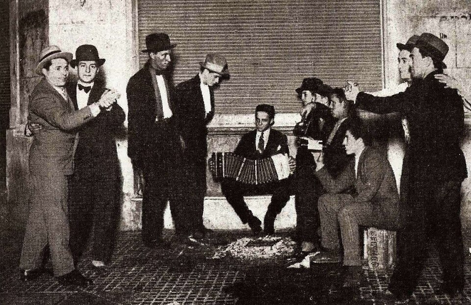 Historic Argentine tango dancers and musicians with a bandoneon player.