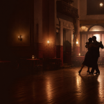 Portrait-free editorial image of an anonymous tango couple in a warm Buenos Aires dance hall